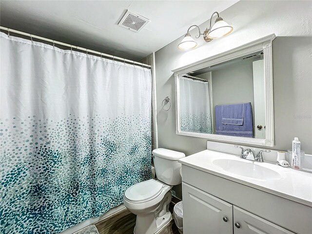 bathroom with vanity, hardwood / wood-style floors, toilet, and walk in shower