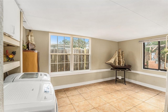 washroom with cabinets, independent washer and dryer, and light tile patterned flooring