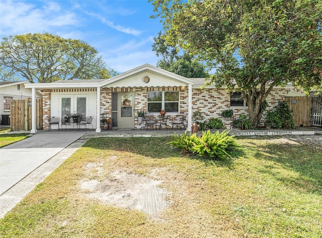 ranch-style home with central AC unit, a front yard, and french doors