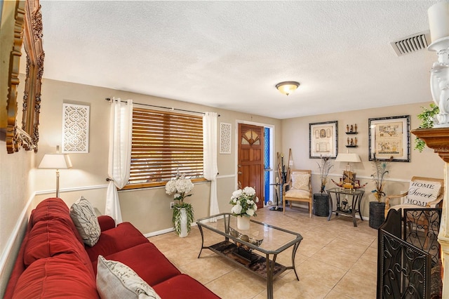 living room with a textured ceiling and light tile patterned floors