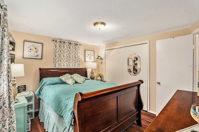 bedroom with dark wood-type flooring, a textured ceiling, and a closet