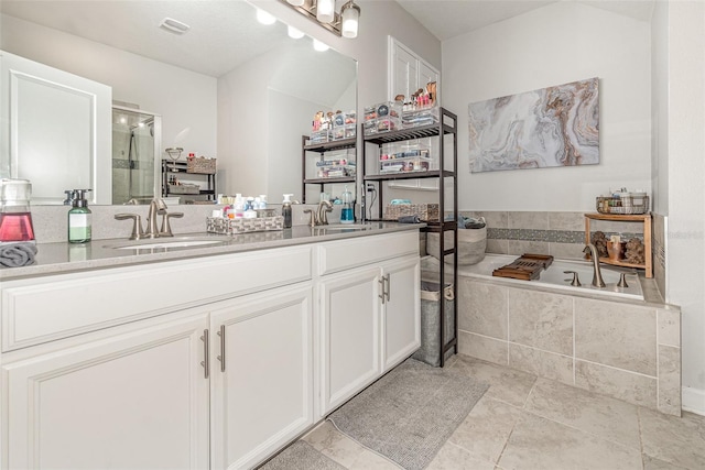 bathroom featuring shower with separate bathtub, vanity, and tile patterned floors