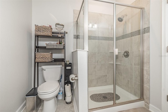 bathroom with tile patterned flooring, a shower with shower door, and toilet