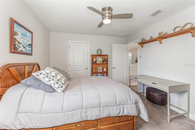 carpeted bedroom featuring a textured ceiling and ceiling fan