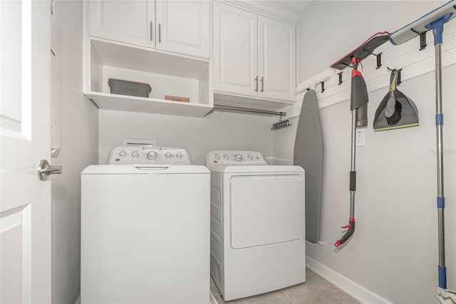 washroom with washer and dryer, cabinets, and light tile patterned floors