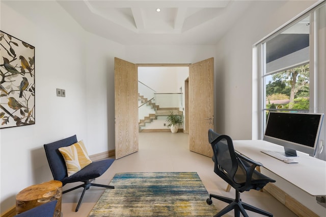 home office with light tile patterned flooring and a tray ceiling