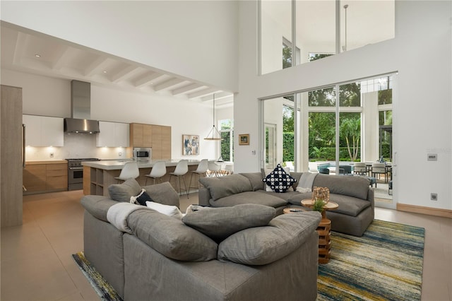 tiled living room with beamed ceiling and high vaulted ceiling