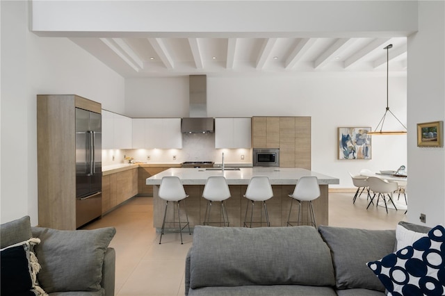 kitchen with tasteful backsplash, decorative light fixtures, white cabinets, built in appliances, and beam ceiling