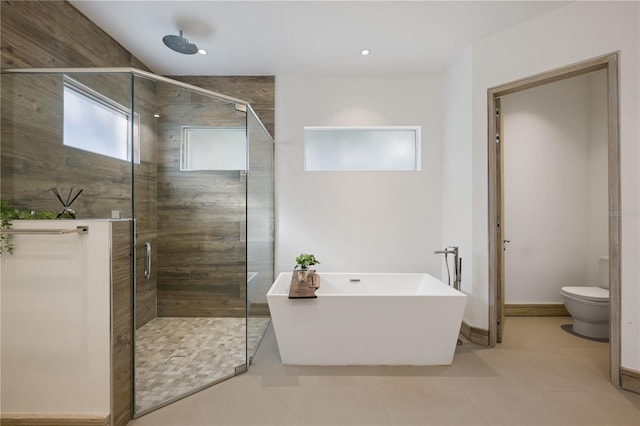 bathroom featuring toilet, plus walk in shower, and tile patterned flooring