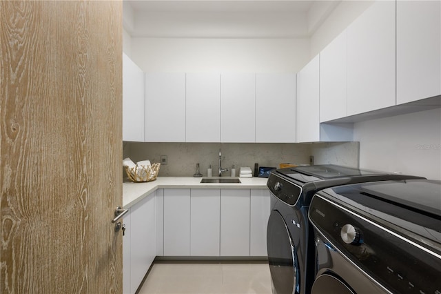 laundry area with sink, independent washer and dryer, and cabinets