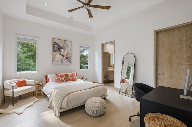 bedroom featuring ensuite bathroom, light wood-type flooring, and ceiling fan