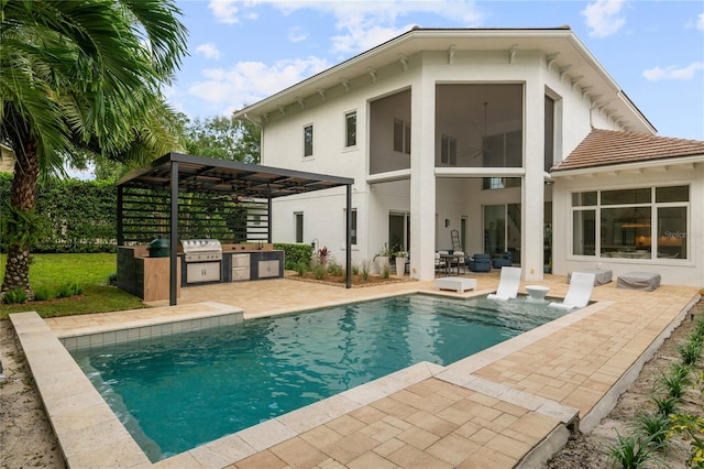 rear view of property with a patio area, a sunroom, a pergola, ceiling fan, and an outdoor kitchen