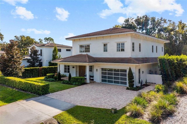 mediterranean / spanish house featuring a front yard and a garage