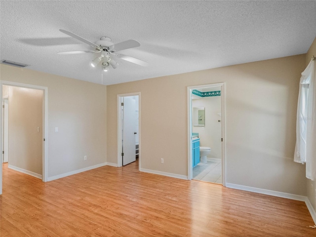 unfurnished room with a textured ceiling, light hardwood / wood-style floors, and ceiling fan