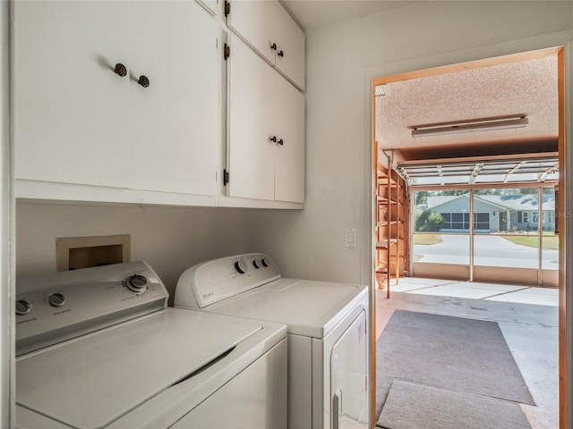 laundry room featuring cabinets, washer and dryer, and a textured ceiling