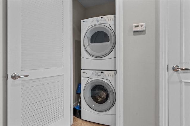 laundry room with stacked washer / dryer and light tile patterned flooring