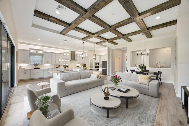 living room featuring coffered ceiling, a notable chandelier, beamed ceiling, and light hardwood / wood-style flooring