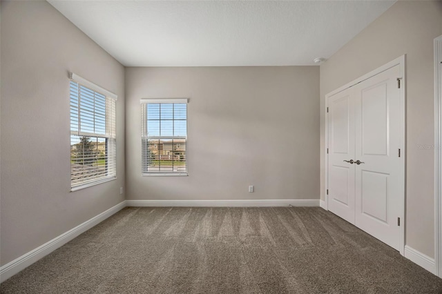 unfurnished room with dark colored carpet