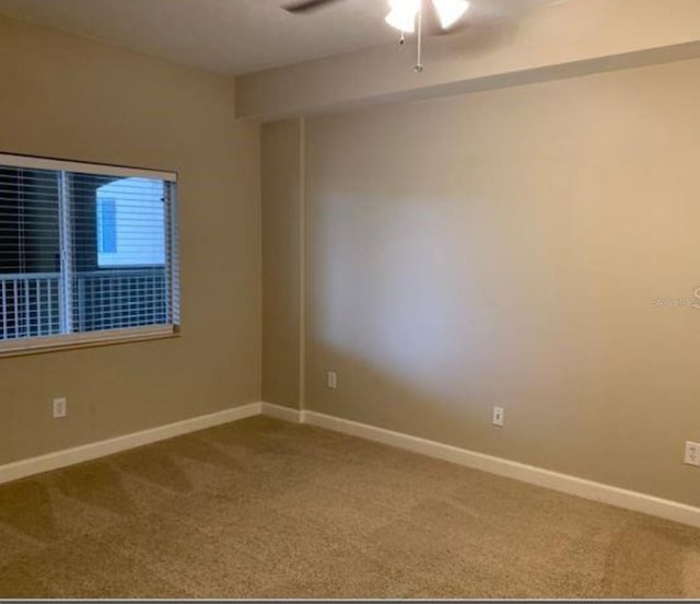 carpeted spare room with ceiling fan