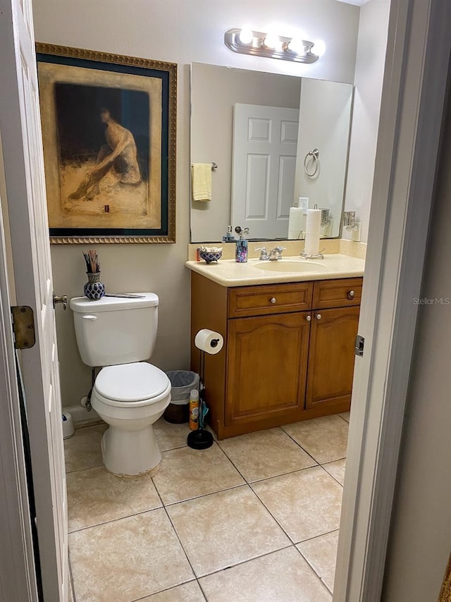 bathroom with toilet, tile patterned flooring, and vanity