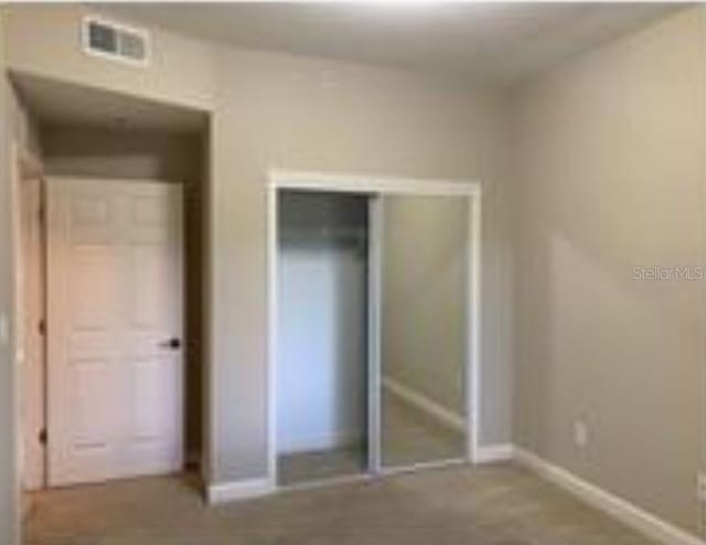 unfurnished bedroom featuring a closet, visible vents, and baseboards