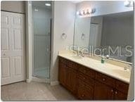 bathroom with a stall shower and double vanity