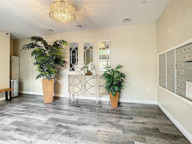 interior space featuring mail area, visible vents, and wood finished floors