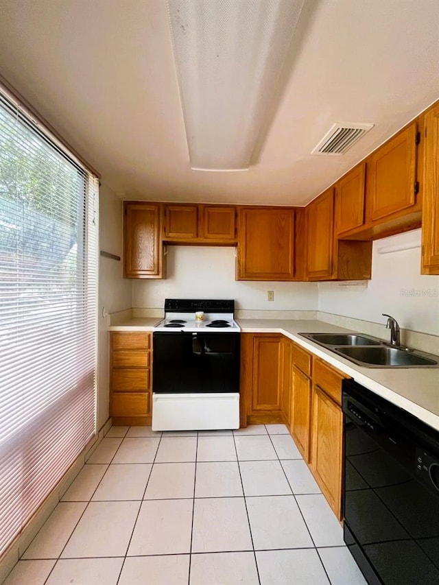 kitchen featuring sink, dishwasher, electric range, and light tile patterned floors