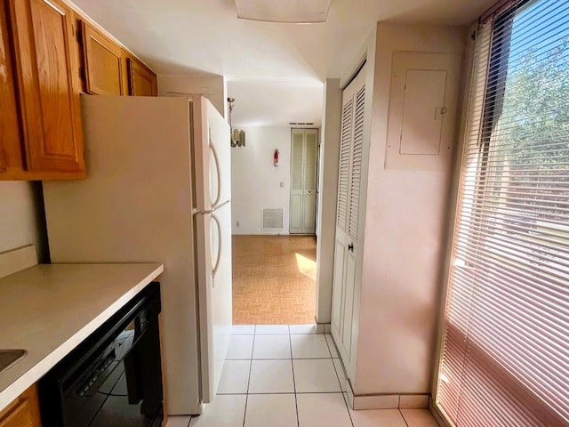 kitchen with black dishwasher, electric panel, white refrigerator, and light tile patterned floors