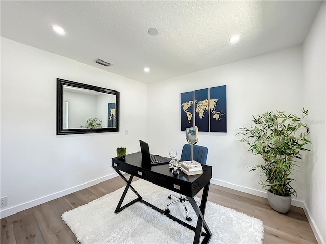 office area with a textured ceiling and wood-type flooring