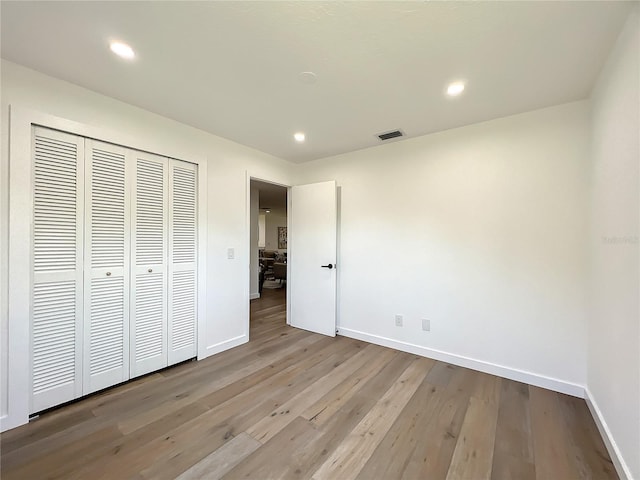 unfurnished bedroom featuring a closet and light wood-type flooring