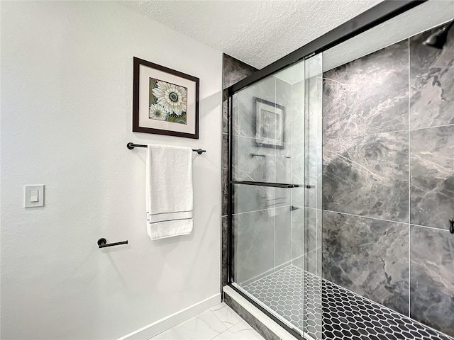 bathroom with a textured ceiling and a shower with shower door