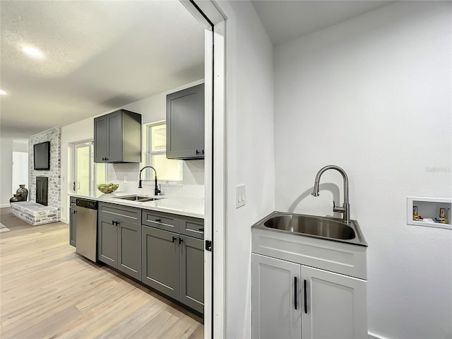 kitchen with light hardwood / wood-style floors, dishwasher, and sink