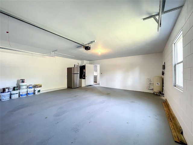 garage with a garage door opener and stainless steel fridge