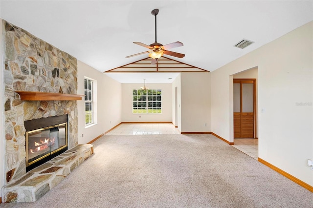 unfurnished living room with a stone fireplace, lofted ceiling, and light colored carpet