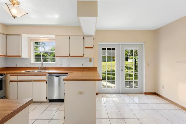 kitchen with butcher block counters, appliances with stainless steel finishes, and plenty of natural light