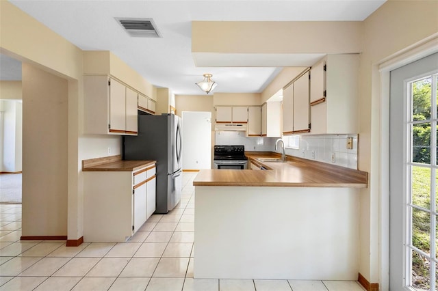 kitchen featuring sink, appliances with stainless steel finishes, kitchen peninsula, and light tile patterned floors