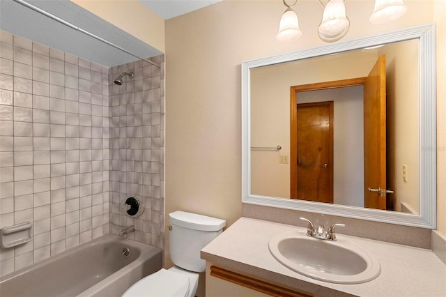 full bathroom featuring toilet, tiled shower / bath, and vanity