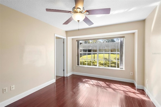 unfurnished room with dark hardwood / wood-style floors, a textured ceiling, and ceiling fan