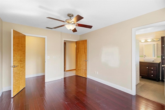 unfurnished bedroom with ensuite bath, sink, hardwood / wood-style floors, and ceiling fan