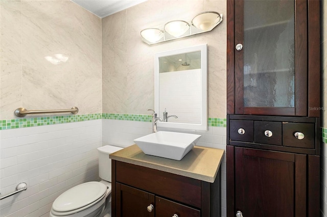 bathroom with vanity, tile walls, and toilet