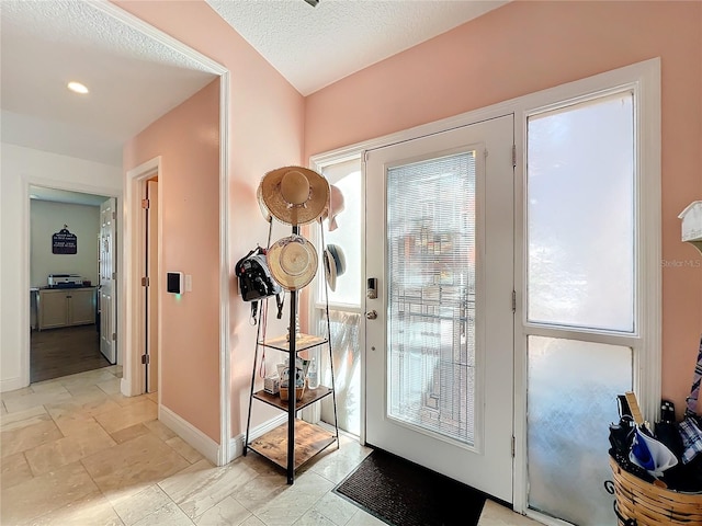 doorway with plenty of natural light and a textured ceiling