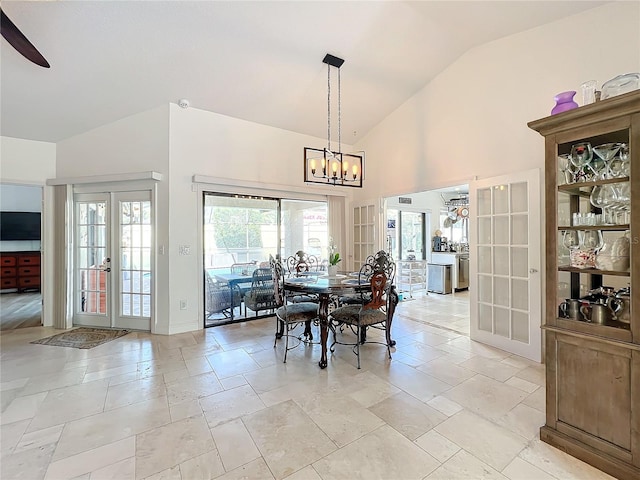 dining area featuring french doors, ceiling fan with notable chandelier, and vaulted ceiling