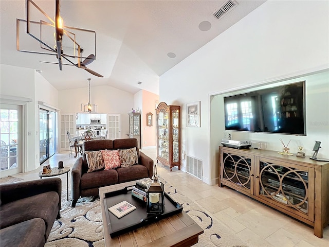 living room featuring high vaulted ceiling and an inviting chandelier