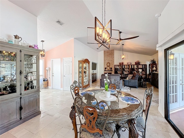 dining area with high vaulted ceiling and a chandelier