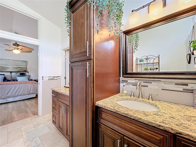 bathroom featuring vanity, decorative backsplash, and ceiling fan