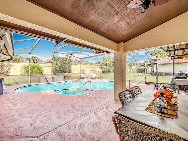 view of swimming pool with a patio, ceiling fan, and glass enclosure