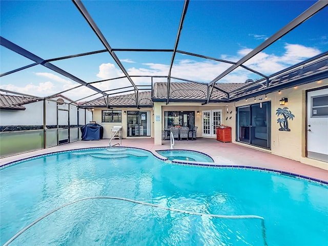 view of swimming pool with glass enclosure, french doors, an in ground hot tub, a patio, and grilling area