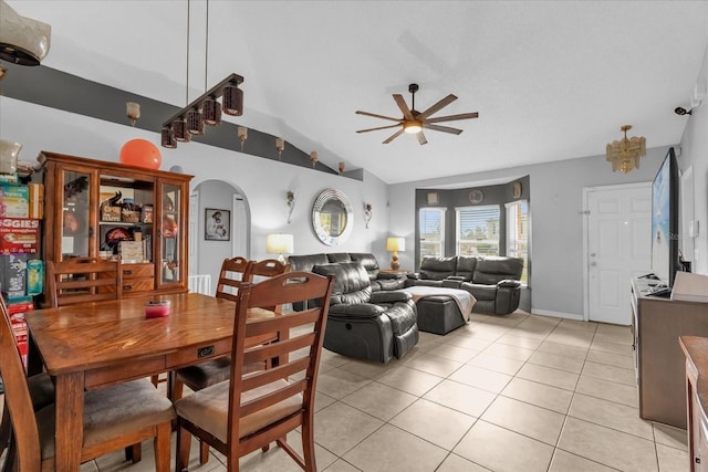 dining space featuring light tile patterned flooring, vaulted ceiling, and ceiling fan