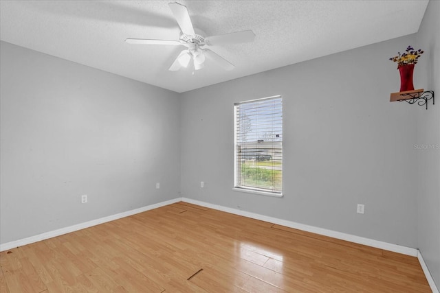 unfurnished room with ceiling fan, wood-type flooring, and a textured ceiling